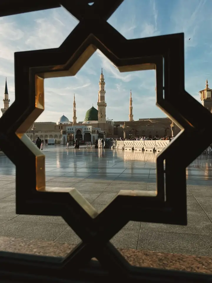 The Green Dome of Al-Masjid an-Nabawi framed by an ornate metal screen in Madina
